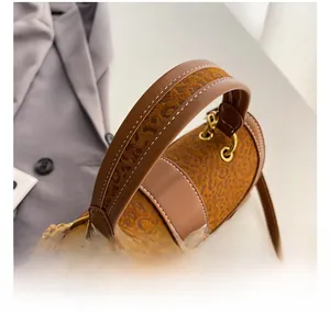 Detail of the stitching on leather handles and metal buckle of the vintage barrel bag