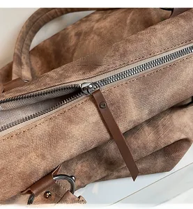 Détail de la fermeture éclair en métal et de la doublure chevron d'un grand sac en toile