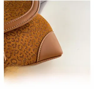 Detail of animal print suede texture and precision white stitching on a retro handbag