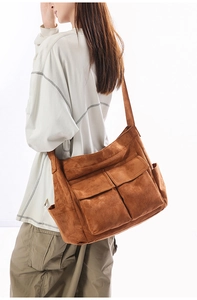 Detail view of large brown faux suede shoulder bag with dual front utility flap pockets