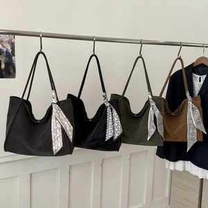 Hanging row of large vintage tote bags in four colors with decorative silk scarves