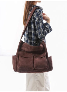 Detail view of a large brown vintage messenger bag with multiple front flap pockets