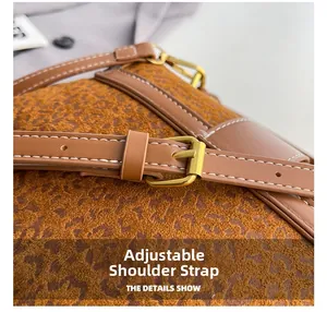Detail of adjustable leather shoulder strap with gold buckle on a leopard print bag