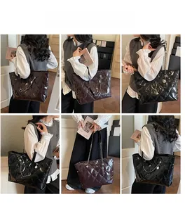 Detail view of quilted tote bag in brown and black with silver chain straps