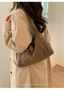 Retro dark brown suede shoulder bag paired with a beige trench coat for a minimalist look