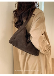 Detail of retro dark brown suede tote bag with a silver square buckle on the shoulder strap