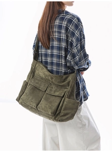 Detail view of retro olive green canvas messenger bag with large functional pockets