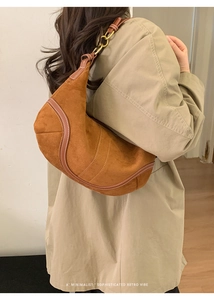 Détail du sac hobo en daim caramel avec surpiq coutures contrastées et anneaux vintage
