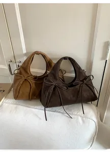 Vue détaillée de sacs demi-lune en marron et café foncé avec des nœuds délicats