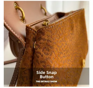Detail of leopard print suede bag with metal side snap button and white stitching