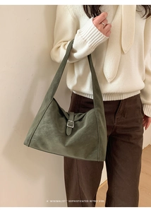 Minimalist deep green suede tote bag featuring a vintage metal buckle and shoulder strap