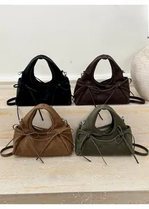 Gros plan de sacs à nœud en quatre couleurs avec poignée ronde et texture en daim élégante
