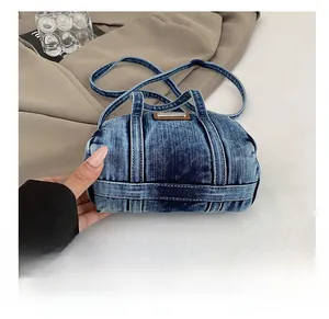 Close-up of durable washed denim base and stitching details on the crossbody bag