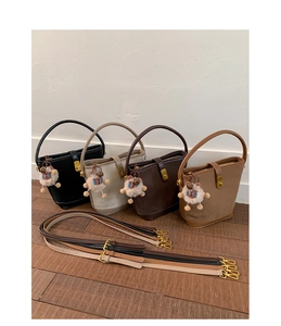 Multiple colors of matte leather bucket bags with handles and plush pendant charms