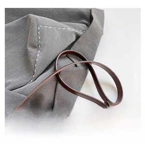 Macro shot of dark brown leather shoulder strap with neat stitching and smooth edges