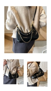 Detail of glossy black crescent bag featuring gold chain and adjustable leather strap