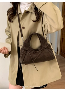 Vue détaillée du sac à main en daim marron foncé avec nœud décoratif et texture rétro