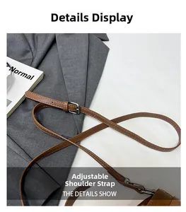 Detail of adjustable brown pebbled leather shoulder strap with silver metal buckle and hook