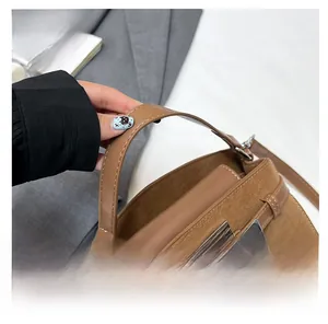 Close-up of brown suede leather tote bag featuring a metallic twist lock and thick handles