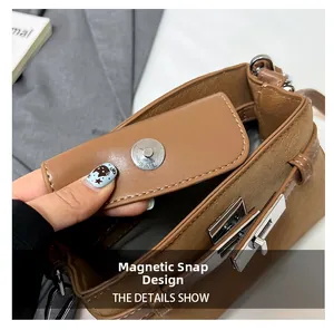 Detail view showing magnetic snap closure and leather texture on a brown square bag