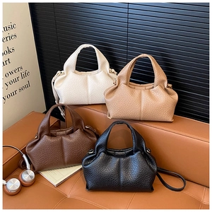Detail of four litchi-textured leather cloud bags in black brown beige and tan colors