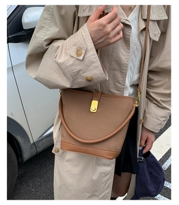 Vista street style di una borsa a secchiello vintage in pelle marrone con fibbia in metallo