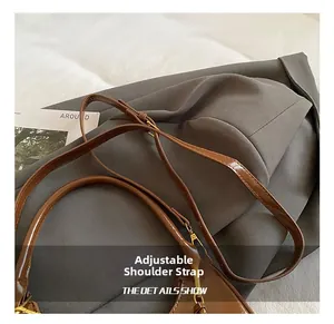 Detail of adjustable strap on brown patent leather bag with premium metal buckles