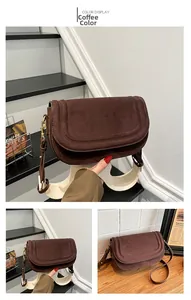 Detail of coffee brown suede saddle bag with dual leather and fabric shoulder straps