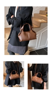 Détail du sac à main en cuir marron foncé montrant les plis souples et la bandoulière