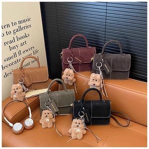 Detailed display of five colorful suede crossbody bags with cute puppy charms and stitching