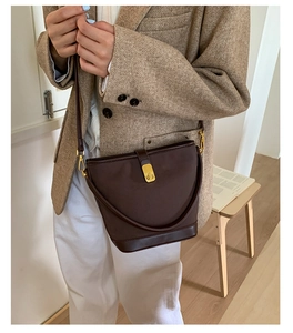 Detail of vintage dark brown bucket bag with gold hardware and smooth leather finish