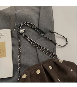 Detail of dark brown matte leather bag featuring silver metal chain and ball slider