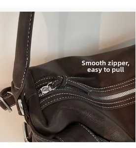 Close-up of smooth silver zipper and contrast stitching on dark brown tote bag