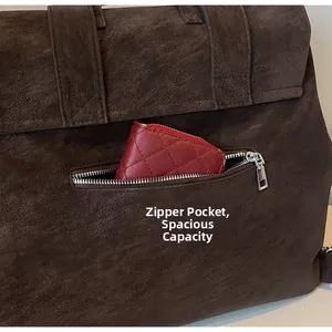 Detail view of large dark brown suede backpack with hidden back zipper and red wallet inside