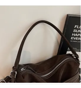 Close-up of vintage dark brown handbag with contrast white stitching and silver zipper