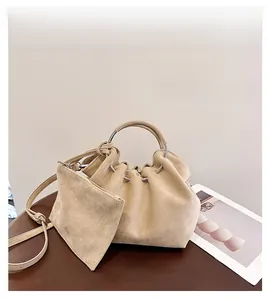 Detail of pleated beige suede cloud bag with silver metal handle and matching coin purse