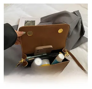Internal storage view of the brown leather crossbody bag with compartments and zipper pocket