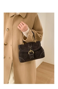 Detail of the vintage suede handbag with contrasting white stitching and gold horseshoe buckle