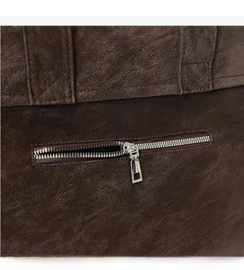 Close-up of smooth silver metal zipper on premium dark brown vintage leather backpack