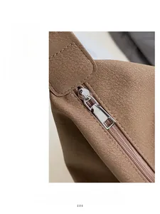 Detail of silver metal zipper and brown lychee grain leather on vintage dumpling bag