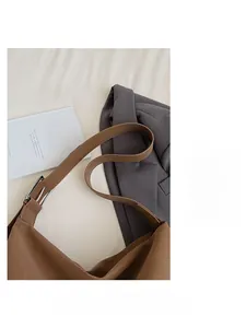 Detail of a brown lychee pattern leather strap with silver adjustable metal buckle