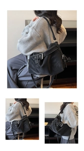 Detailed close-up of retro black tote bag with white contrast stitching and silver buckle