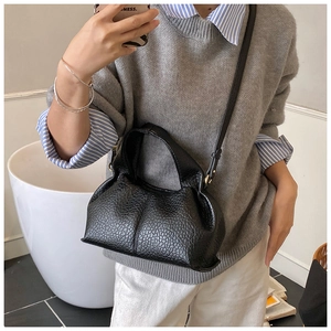 Sac nuage en cuir noir grainé avec détails dorés et bandoulière réglable élégante