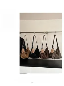 Detailed view of four vintage PU leather tote bags with cute bear pendants hanging