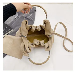 Detail view of khaki suede bucket bag interior showing spacious capacity and silver metal ring