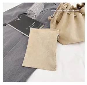 Detail showing beige suede bucket bag with matching small pouch used separately