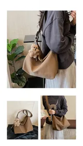 Detail of a brown PU leather tote bag with a cute plush bear charm in a lifestyle setting