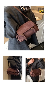 Detail view of coffee suede crossbody bag featuring retro metal buckles and side pocket