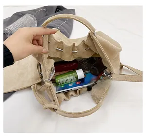 Interior view showing the large capacity of the beige pleated suede bucket bag