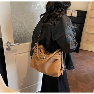 Detail of caramel leather hobo bag with adjustable wide strap and buckle accent
